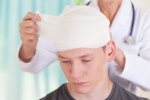 Man suffering from a traumatic brain injury gettng bandages changed