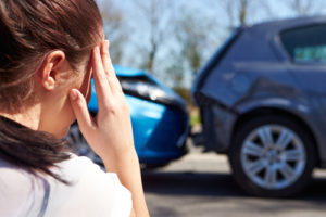 female looking at car collision