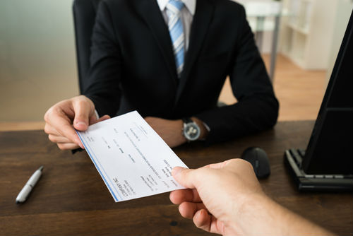 Compensation check being handed to injured motorist for damages from a truck accident