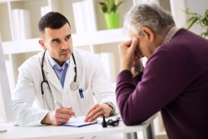 doctor listening to elder patient