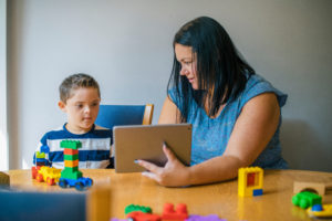 child that qualifies for social security disability playing with mom